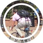 A college student wearing a purple shirt riding a bike